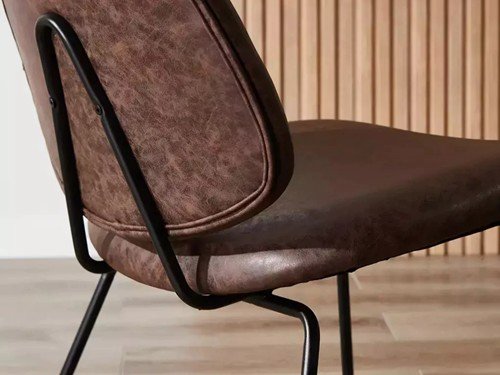 Poltrona Sucre tapizada con base metálica negra